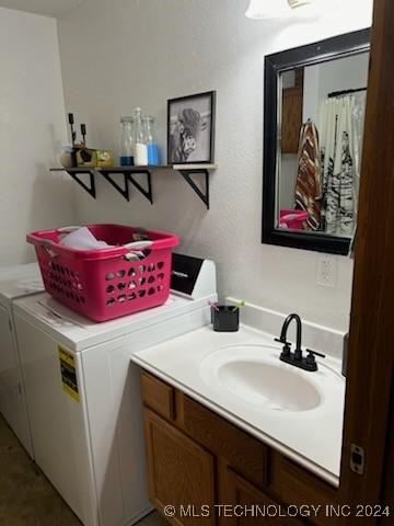 clothes washing area with separate washer and dryer and sink