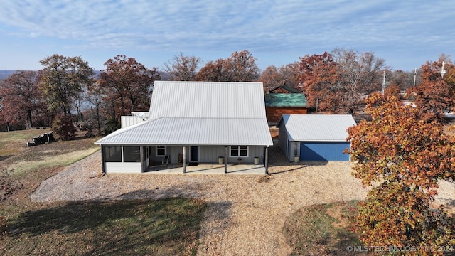 exterior space featuring an outbuilding, a garage, and a sunroom