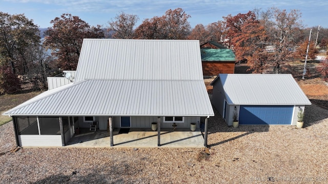 rear view of house featuring a garage, a patio area, and a sunroom