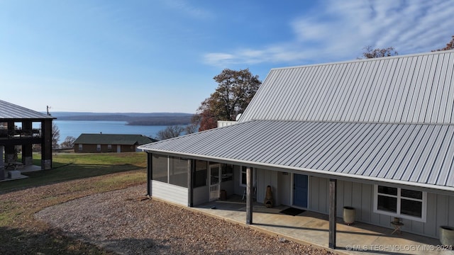 rear view of house featuring a patio area and a water view