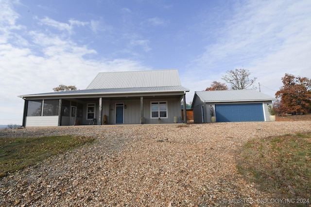 view of front facade featuring covered porch, a sunroom, and a garage