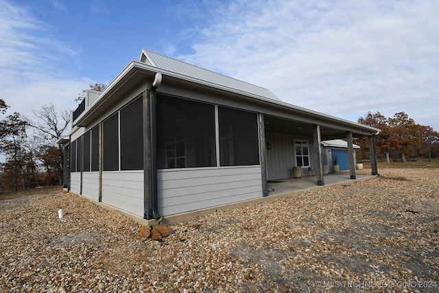 view of side of home with a patio and a sunroom