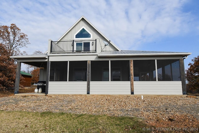 rear view of property with a balcony and a sunroom