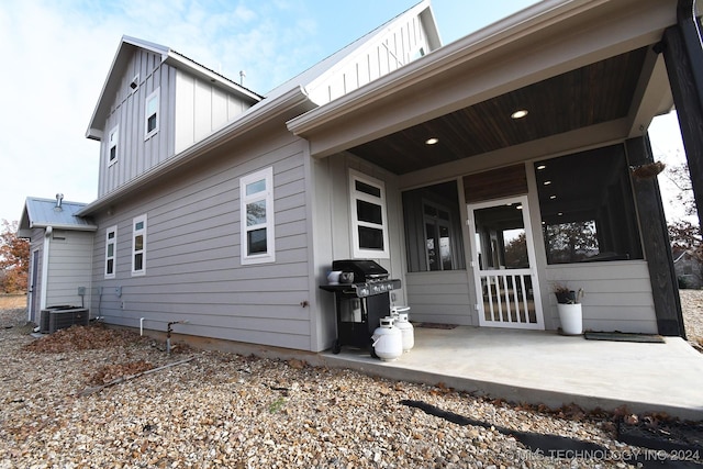 back of property featuring a patio, central AC unit, and a sunroom