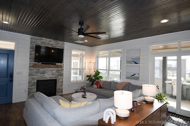 living room featuring a fireplace, hardwood / wood-style flooring, ceiling fan, and wood walls