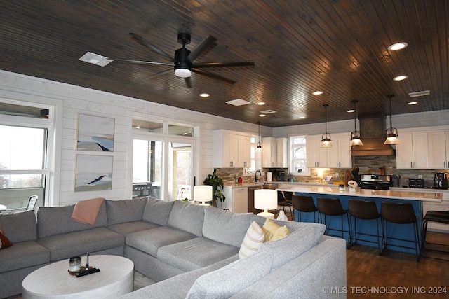 living room with wood walls, dark hardwood / wood-style flooring, ceiling fan, and wood ceiling