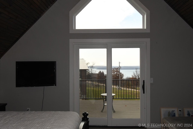 bedroom with a water view, high vaulted ceiling, and multiple windows