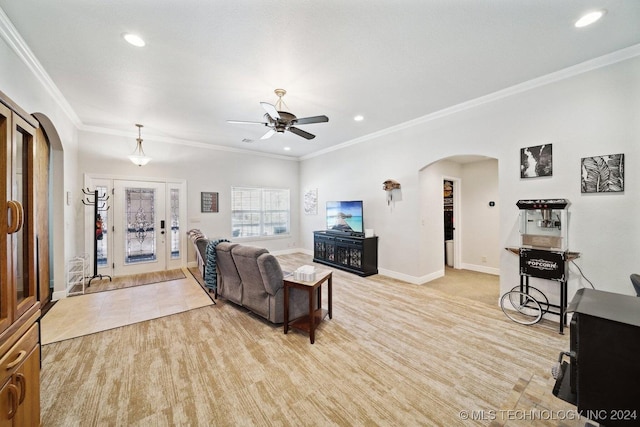 living room with ceiling fan, ornamental molding, and light carpet