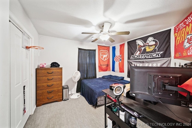 bedroom featuring carpet flooring, ceiling fan, a textured ceiling, and a closet