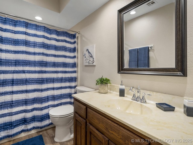 bathroom featuring hardwood / wood-style floors, curtained shower, vanity, and toilet