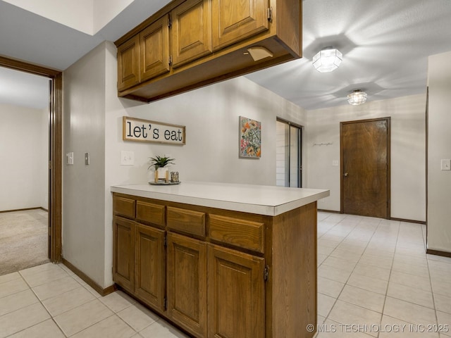 kitchen featuring kitchen peninsula and light carpet