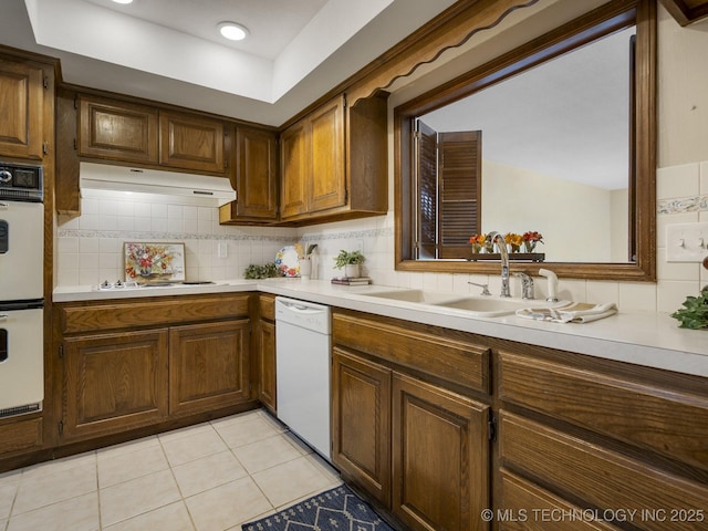 kitchen with white appliances, decorative backsplash, sink, and light tile patterned floors