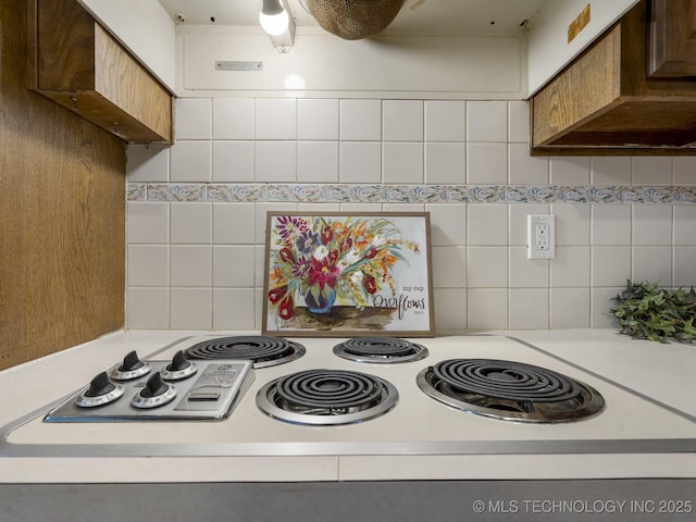 kitchen featuring white electric cooktop, backsplash, and premium range hood