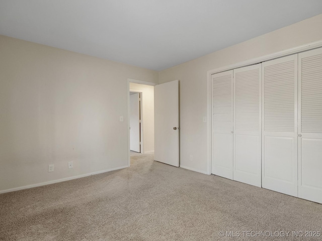 unfurnished bedroom with a closet and light carpet