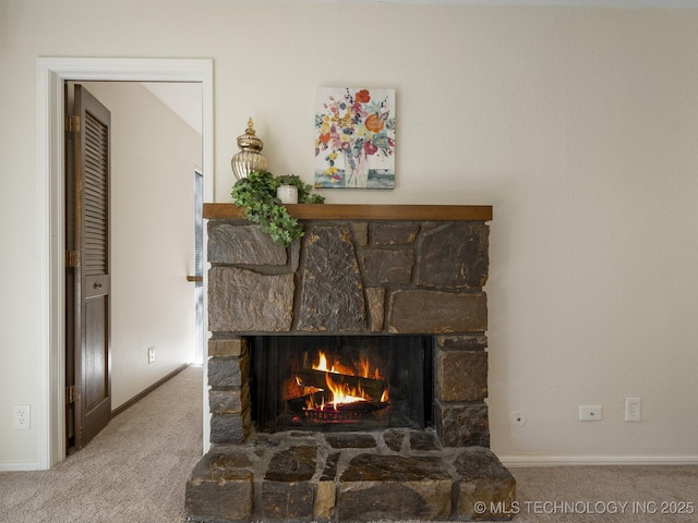 details featuring a stone fireplace, carpet, and baseboards