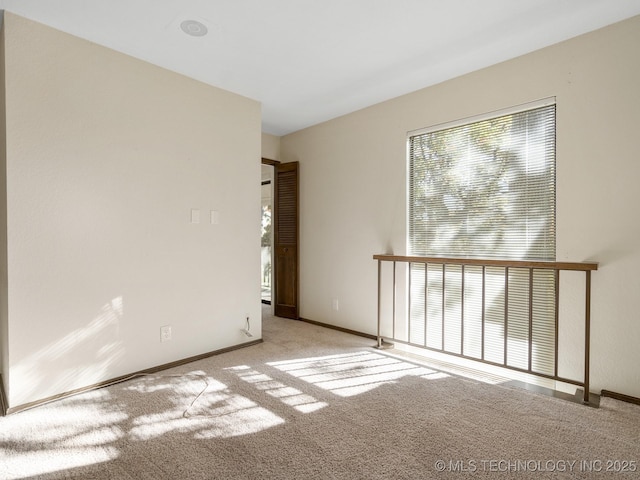 carpeted spare room featuring baseboards