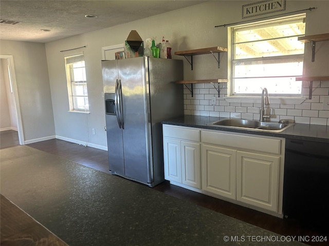 kitchen featuring white cabinets, stainless steel fridge, a healthy amount of sunlight, and sink