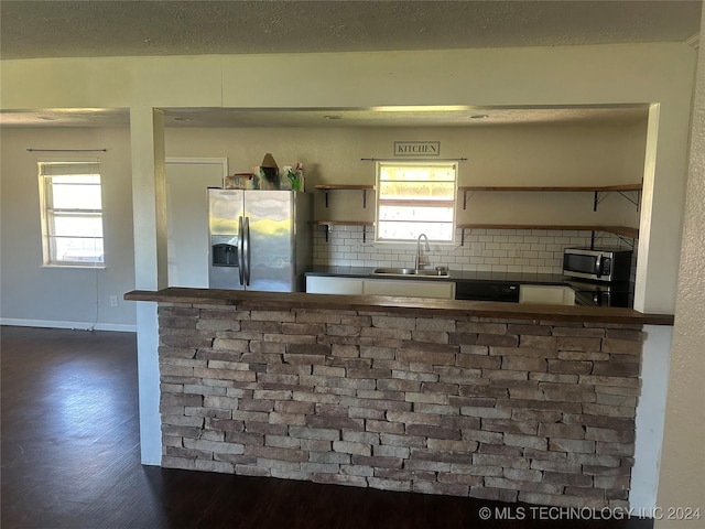 kitchen with backsplash, a healthy amount of sunlight, sink, and appliances with stainless steel finishes