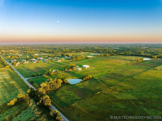 aerial view at dusk with a rural view and a water view