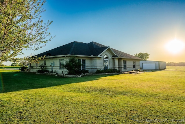 view of front facade with a lawn, an outbuilding, and a garage