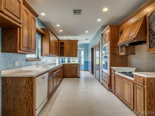 kitchen featuring ceiling fan, sink, stainless steel appliances, and custom range hood