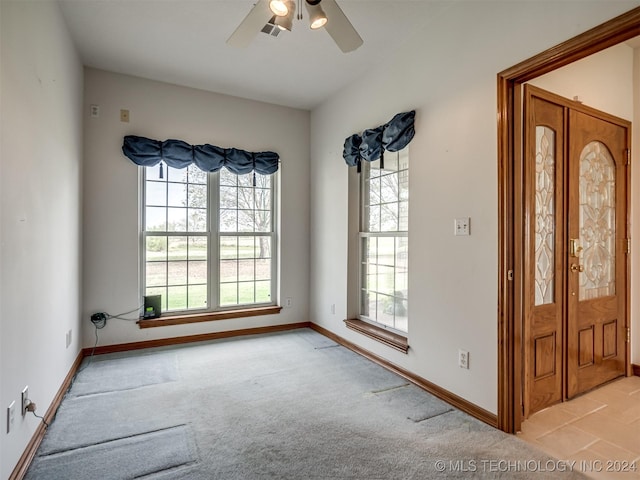 carpeted spare room with ceiling fan and french doors