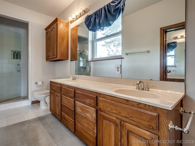 bathroom featuring vanity, a shower with door, tile patterned flooring, and toilet