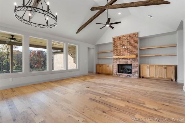 unfurnished living room featuring high vaulted ceiling, ceiling fan with notable chandelier, a brick fireplace, beamed ceiling, and light hardwood / wood-style floors