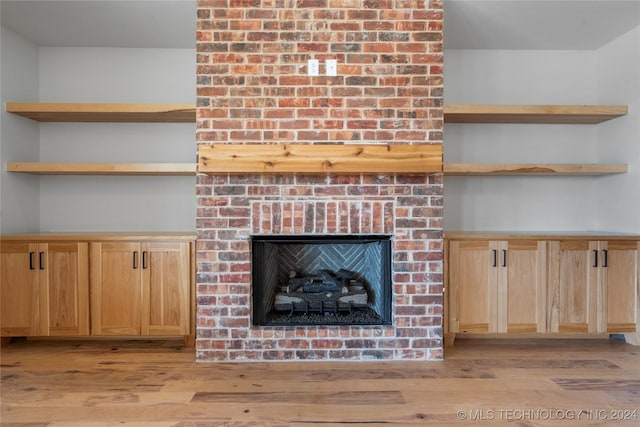 interior details with a brick fireplace and hardwood / wood-style flooring