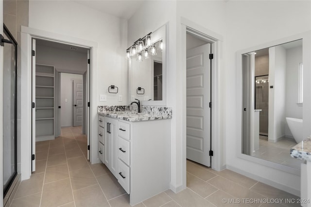 bathroom with tile patterned flooring, vanity, and separate shower and tub