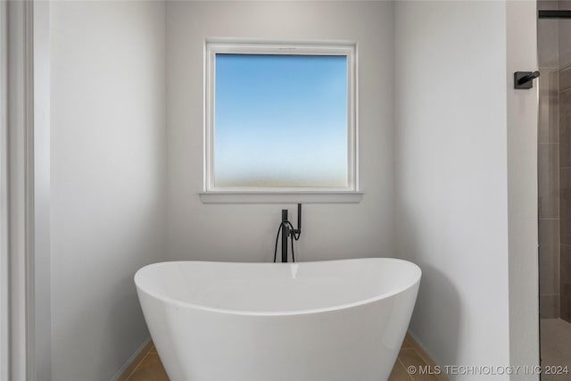 bathroom with tile patterned flooring and a bathtub