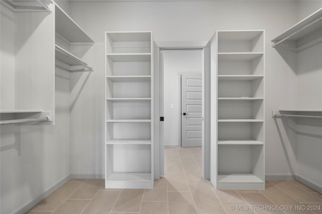 walk in closet with light tile patterned floors