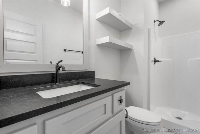 bathroom with a shower, vanity, and toilet