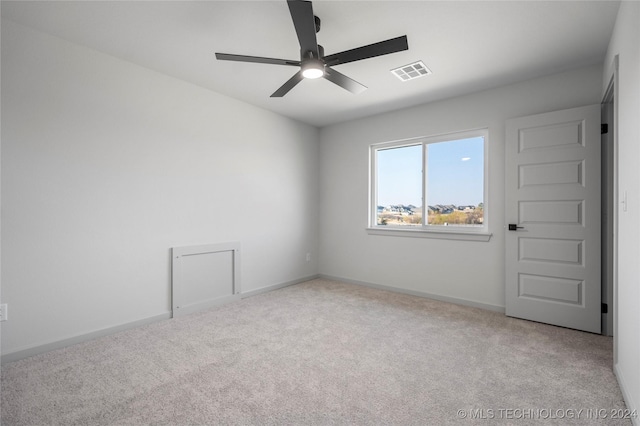 empty room featuring ceiling fan and light colored carpet