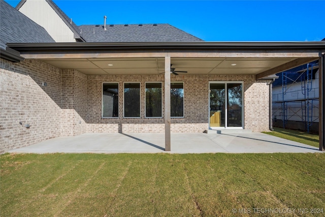 back of property with a yard, ceiling fan, and a patio area