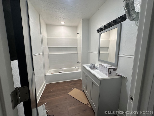 bathroom with vanity, a textured ceiling,  shower combination, and hardwood / wood-style flooring