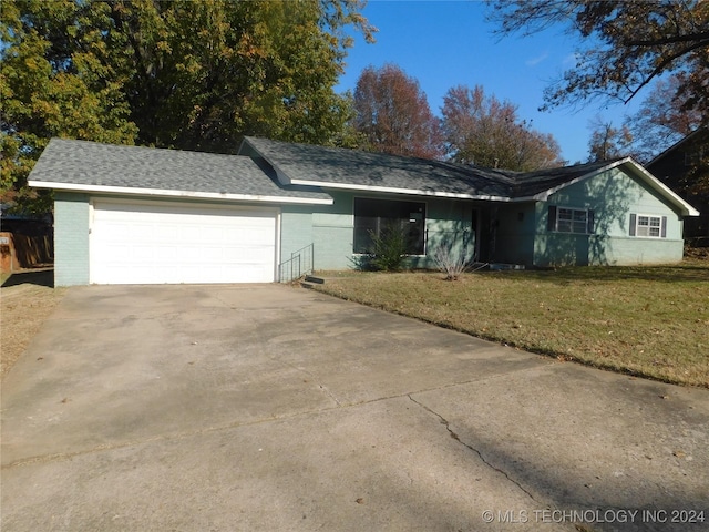 ranch-style home featuring a garage and a front lawn