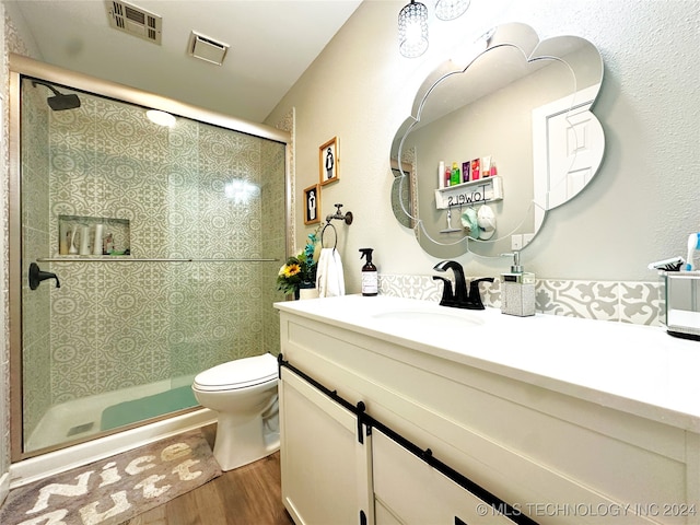 bathroom with vanity, wood-type flooring, an enclosed shower, and toilet