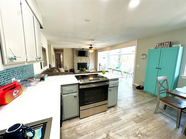 kitchen with backsplash, ceiling fan, electric range, light hardwood / wood-style floors, and white cabinetry