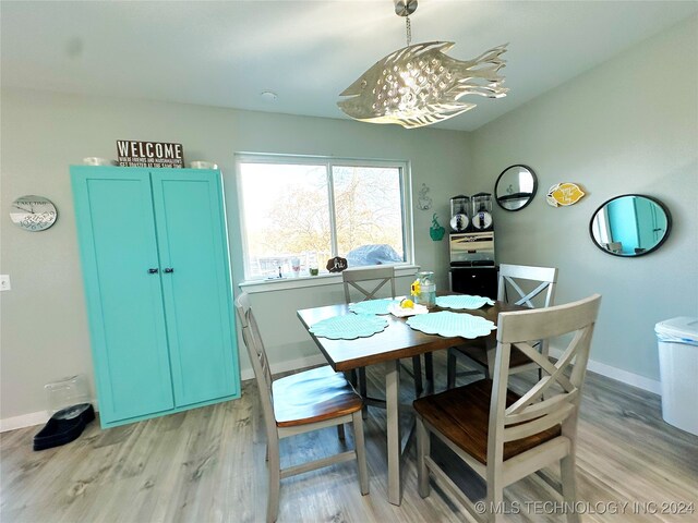 dining space featuring light wood-type flooring and an inviting chandelier