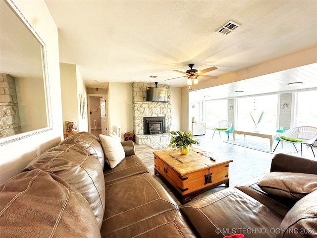 living room featuring ceiling fan and a wood stove