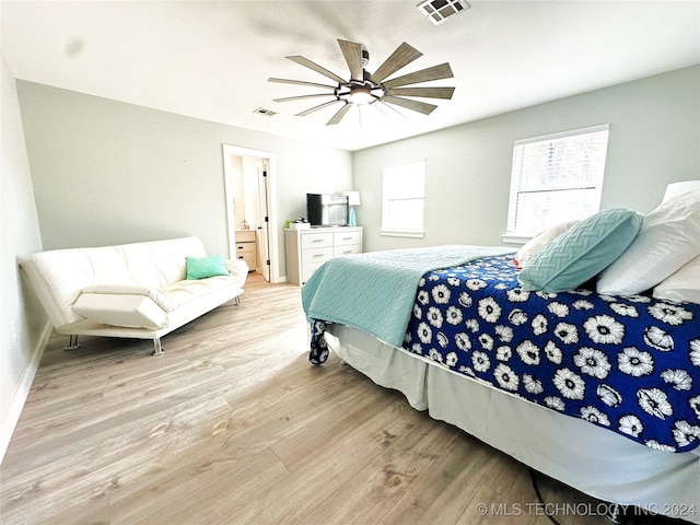 bedroom featuring ensuite bath, ceiling fan, and light wood-type flooring