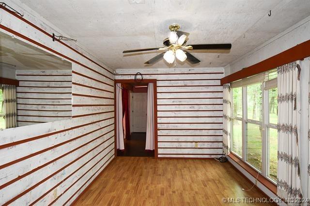 unfurnished sunroom featuring ceiling fan and a healthy amount of sunlight