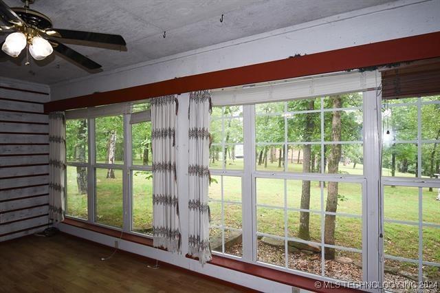 unfurnished sunroom with ceiling fan and a wealth of natural light