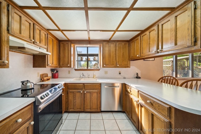 kitchen with a kitchen bar, appliances with stainless steel finishes, a healthy amount of sunlight, and sink