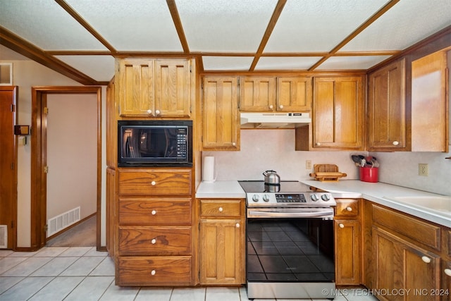 kitchen with a textured ceiling, black microwave, sink, electric stove, and light tile patterned floors