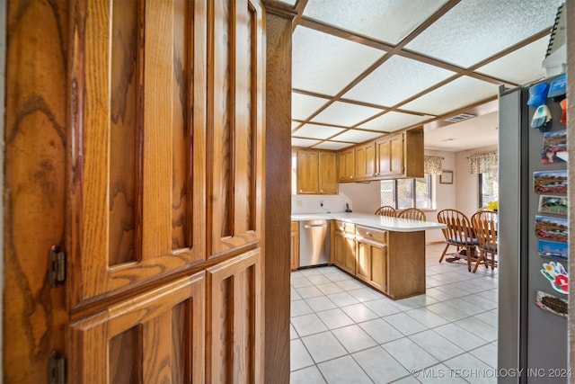 kitchen featuring kitchen peninsula, stainless steel appliances, and light tile patterned floors