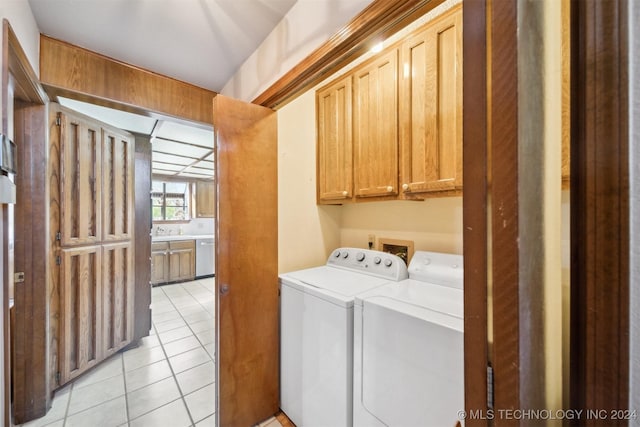 washroom with separate washer and dryer, light tile patterned floors, and cabinets