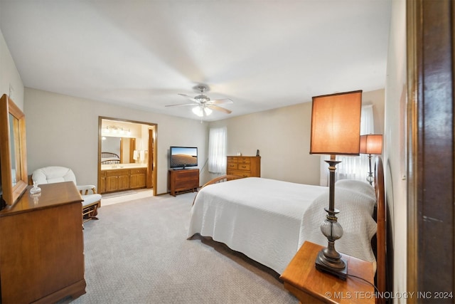 bedroom with ensuite bathroom, ceiling fan, and light carpet