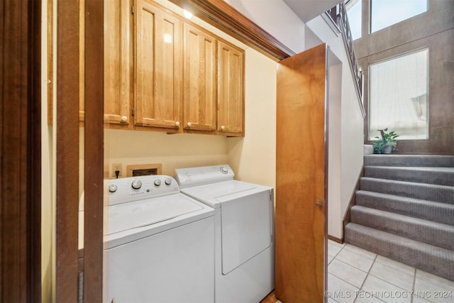 laundry room with cabinets, independent washer and dryer, and light tile patterned floors